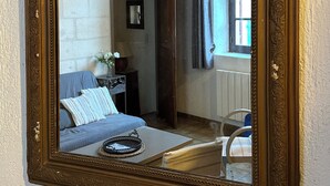 Ein Schlafzimmer mit einem Bett, einem Nachttisch, einer Lampe und einem Fenster mit Vorhängen.