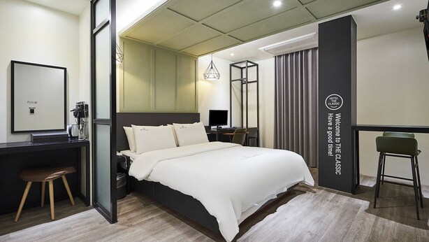 Une chambre d’hôtel moderne équipée d’un grand lit, d’un bureau, d’une chaise et d’un miroir.
