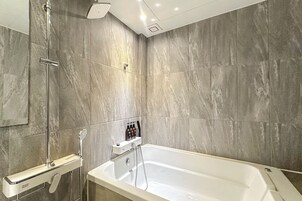 Un baño moderno con bañera, ducha y toallero.