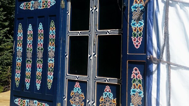 A tent with intricate designs on the sides and a large central window.