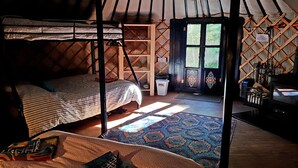 A cozy, rustic room with a bed, a small table, and a window.