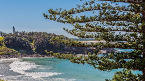 A coastal landscape with a lighthouse, rocky shoreline, and dense greenery. - Craigmore On the Beach Unit 13 - One of the most desirable holiday locations in Yamba. (Yamba)