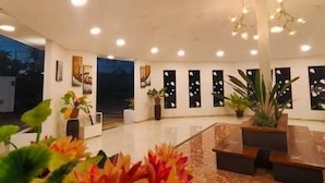 A spacious lobby with a high ceiling, recessed lighting, and a central seating area. - The Story Resort Bohol (Panglao)