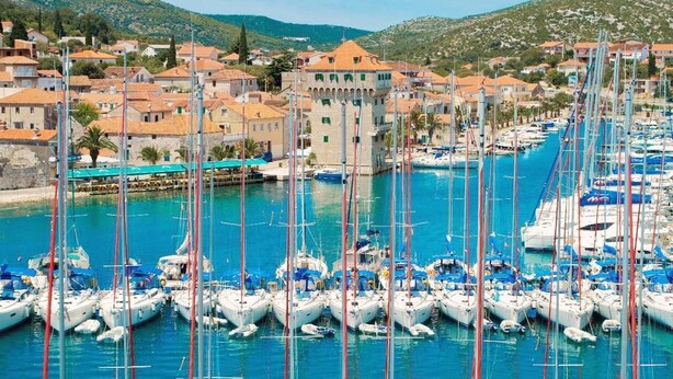 A marina with numerous boats docked, surrounded by traditional buildings with red-tiled roofs. - Enjoy your private pool and outdoor kitchen (Marina)