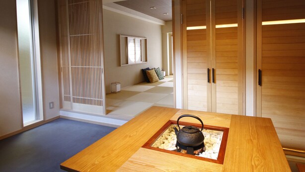 A traditional Japanese room with tatami flooring, a low wooden table with a tea pot, sliding doors, and a shoji screen. - Kotobuki Sou (Tokyo)