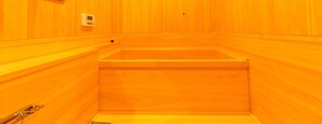 Una sauna con paredes de madera y un banco.