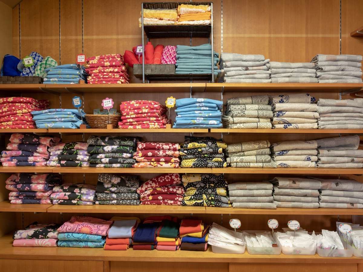 Un magasin où l’on trouve des étagères remplies de textiles pliés, déclinés dans différentes couleurs et différents motifs.