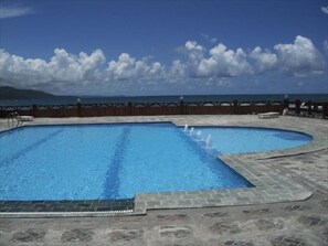 A swimming pool with a wooden deck and a view of the ocean. - Villa Maria Luisa Hotel (Tandag)