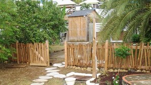 Una terraza de madera con un camino de piedra que lleva a una estructura de madera.