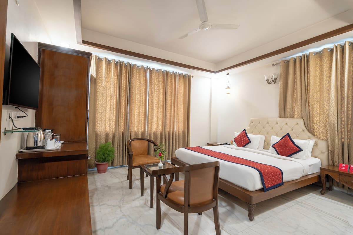 Una habitación de hotel con cama, televisión, escritorio y silla.