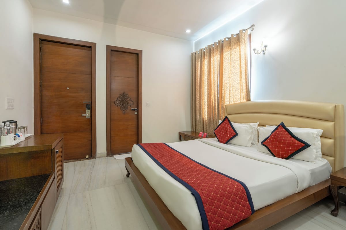 Una habitación de hotel con una cama, un escritorio y dos puertas.