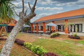 A modern hotel with a swimming pool, orange pillars, and a well-maintained garden. - JnJ Guest House (Penida Island)