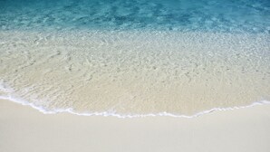 En strand med klart vatten och en sandstrand.