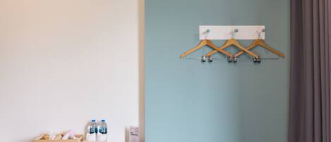 Una habitación con un aparador de madera, un perchero de madera en la pared y un letrero de 'No Fumar'.