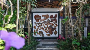 A framed display of wooden toilet and shower parts in a garden setting. - Hiker's Camp at Toya Devasya (Kintamani)