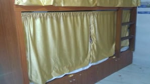 A bunk bed with yellow curtains and a wooden frame.