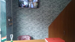 A reception area with a wooden desk, a red folder, and a wall-mounted security camera.