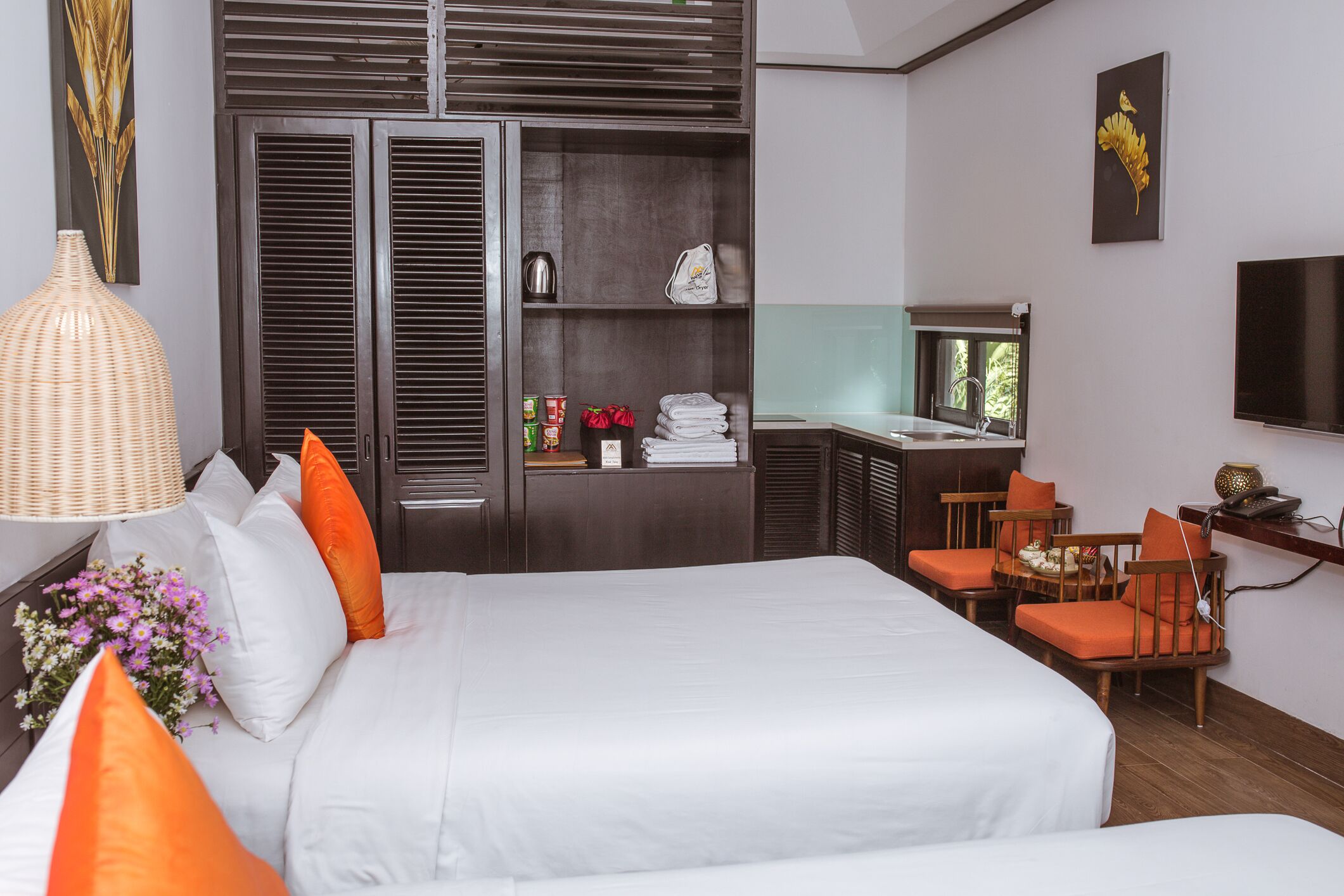 Una habitación de hotel con una cama grande, un escritorio con una silla, un televisor y un armario.