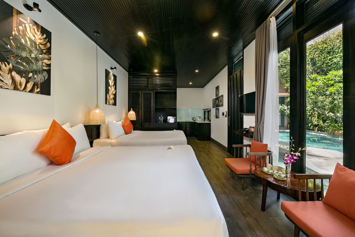Ein Hotelzimmer mit einem großen Bett, einem Schreibtisch und Blick auf einen Pool.