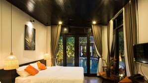 A hotel room with two beds, a desk, a chair, a TV, and a view of the outdoors. - Mai Villa & Apartment (Da Nang)