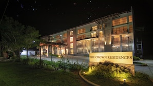 A multi-story building with a sign reading "The Crown Residences."