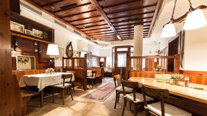 Un interior de madera con comedor, bancos y una larga mesa.