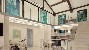 Un loft amplio con techos altos, vigas a la vista y un entrepiso.