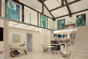 Un loft spazioso con soffitti alti, travi a vista e un soppalco.
