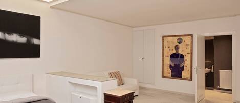 A modern bedroom with a bed, a desk, and a wardrobe.