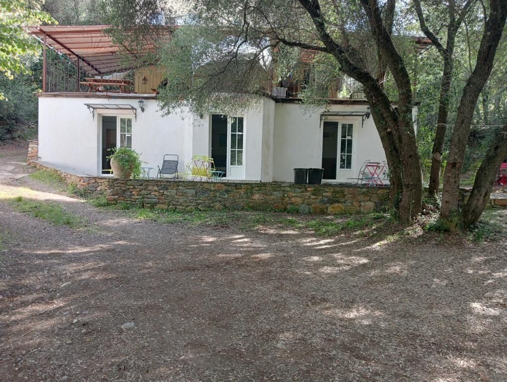 A single-story house with a stone foundation, a covered porch, and a small garden area.