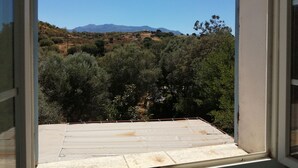 Un balcón con vistas a un paisaje montañoso y montañas a lo lejos.