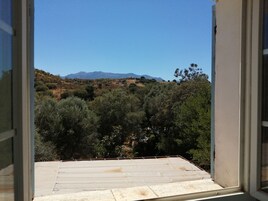 Un balcón con vistas a un paisaje montañoso y montañas a lo lejos.