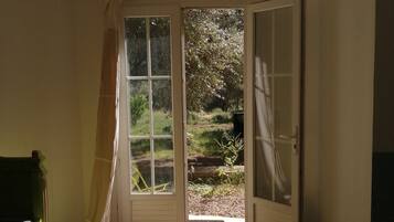 Ein Zimmer mit einer großen Schiebeglasdoor, die zu einem Garten führt.