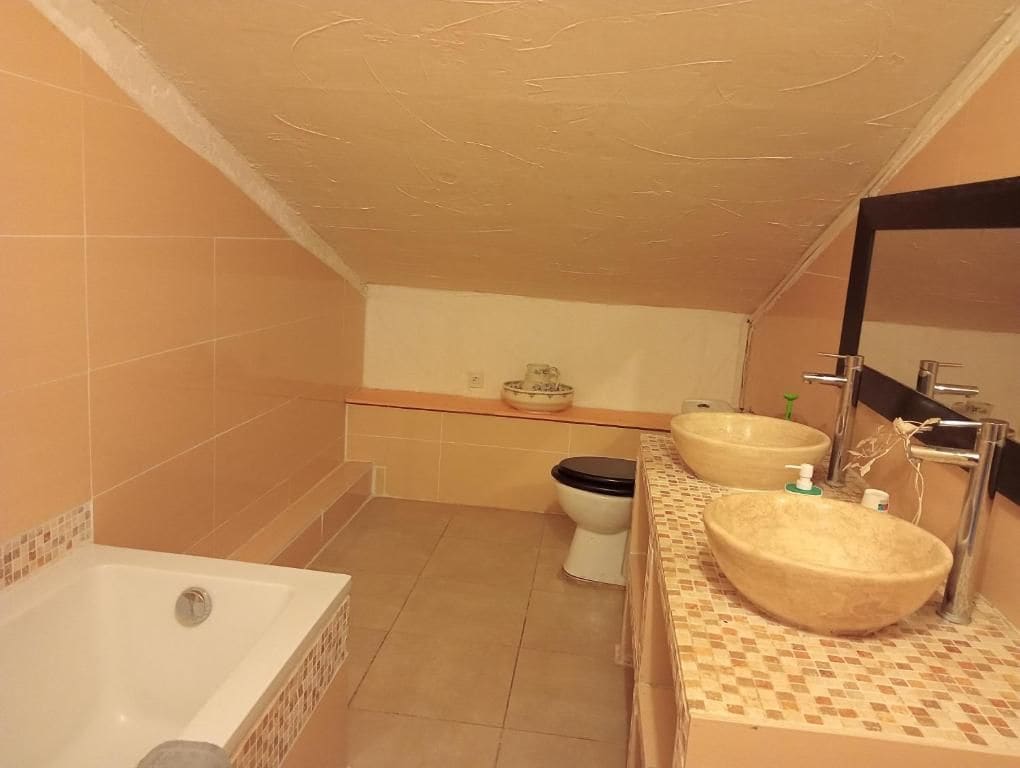 Une salle de bain avec une baignoire, deux lavabos et des toilettes.