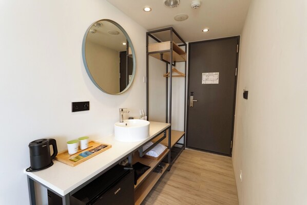 A modern bathroom with a sink, mirror, and storage shelves. - Green Hotel - Chiayi (Chiayi City)