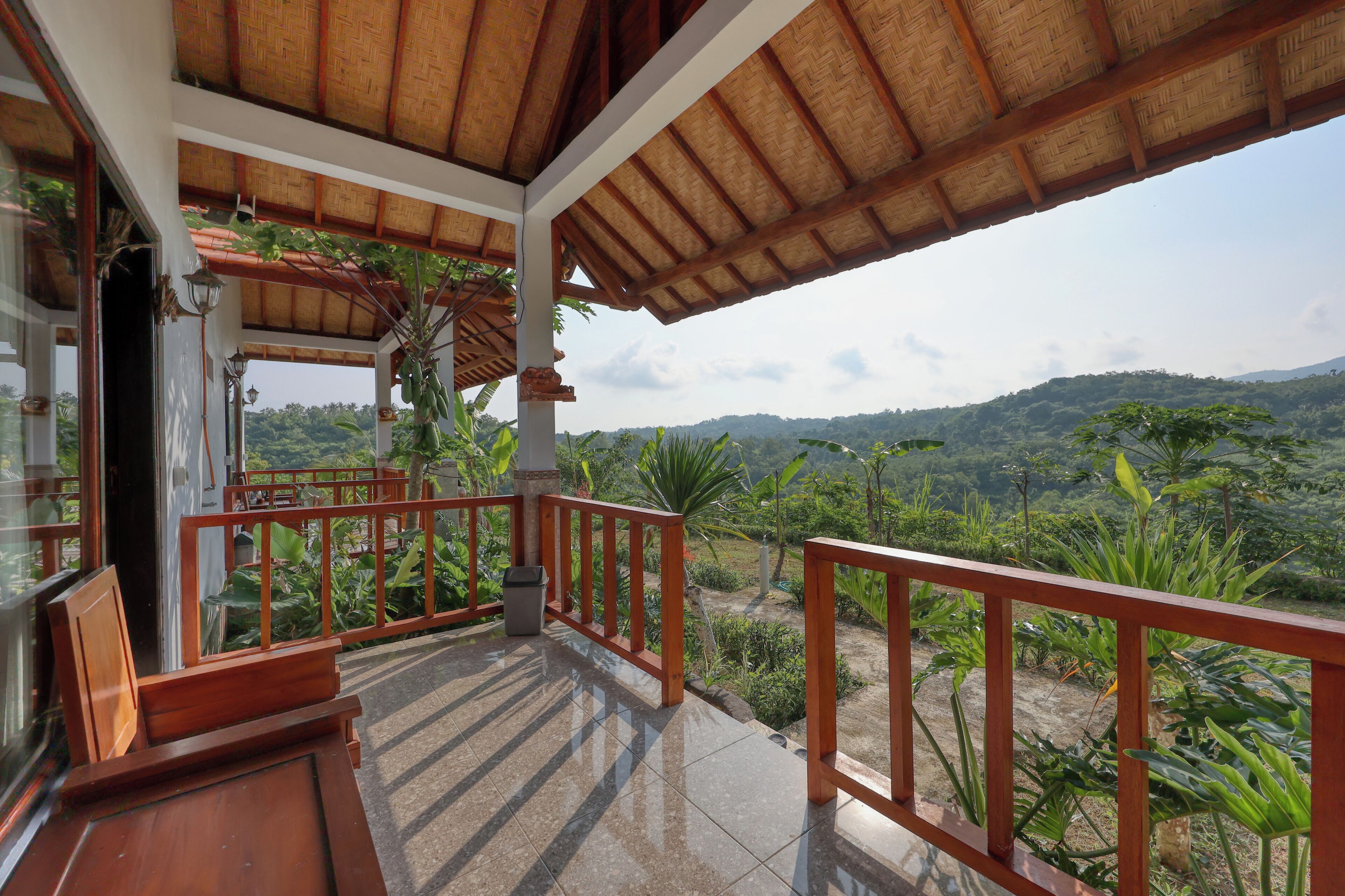 Un balcón techado con vistas a un paisaje exuberante.