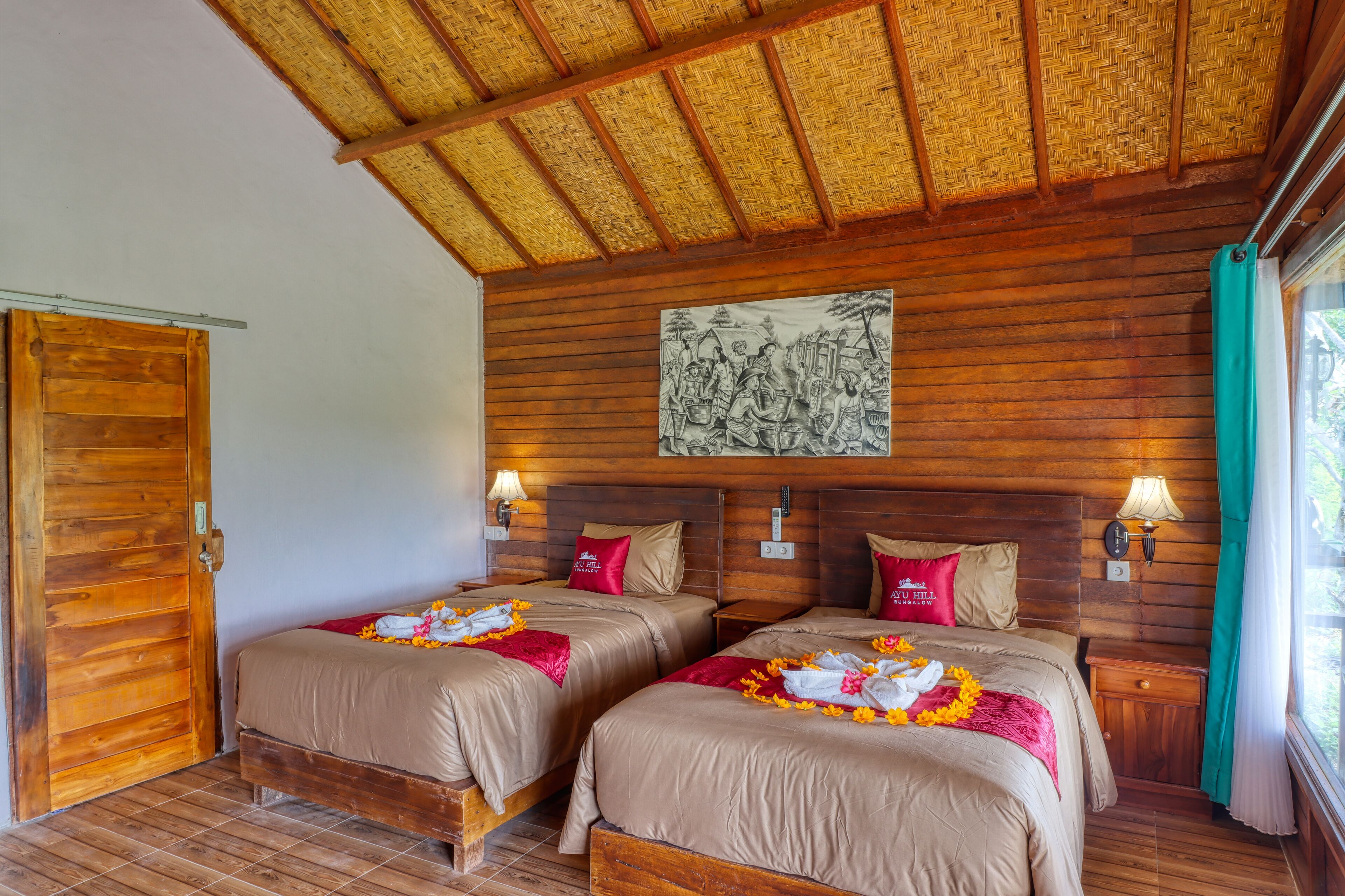Ein Zimmer mit zwei Holzbett, einer gewebten Decke und einem Bild an der Wand.