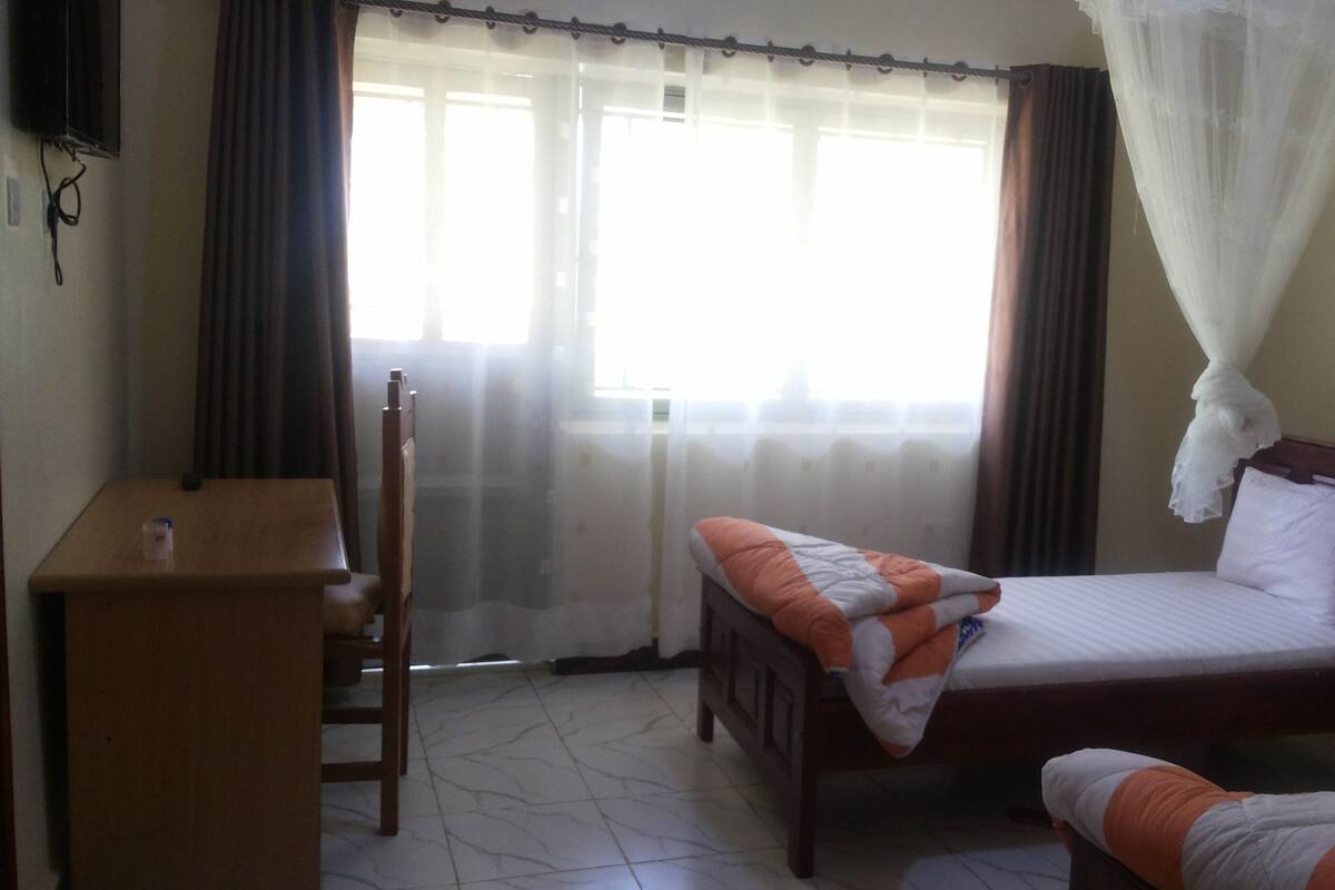 Ein Schlafzimmer mit Bett, Schreibtisch und Stuhl.