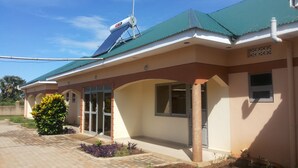 A building with a green roof, a water tank, and a solar panel. - Hotel Premier (Yumbe)