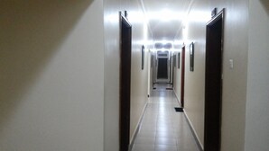 A long, narrow hallway with doors on both sides, leading to rooms. - Hotel Premier (Yumbe)