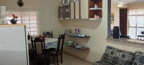 A compact kitchen with a dining table, chairs, and a refrigerator. - HIGH SOBRADO STANDARD SEASON IN NEW CALDAS (CALDAS NOVAS)