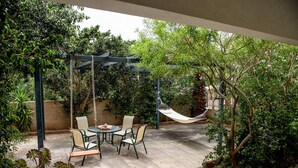 An outdoor patio with a swing set, a hammock, and a table with chairs. - Elies Villa (Kalymnos)