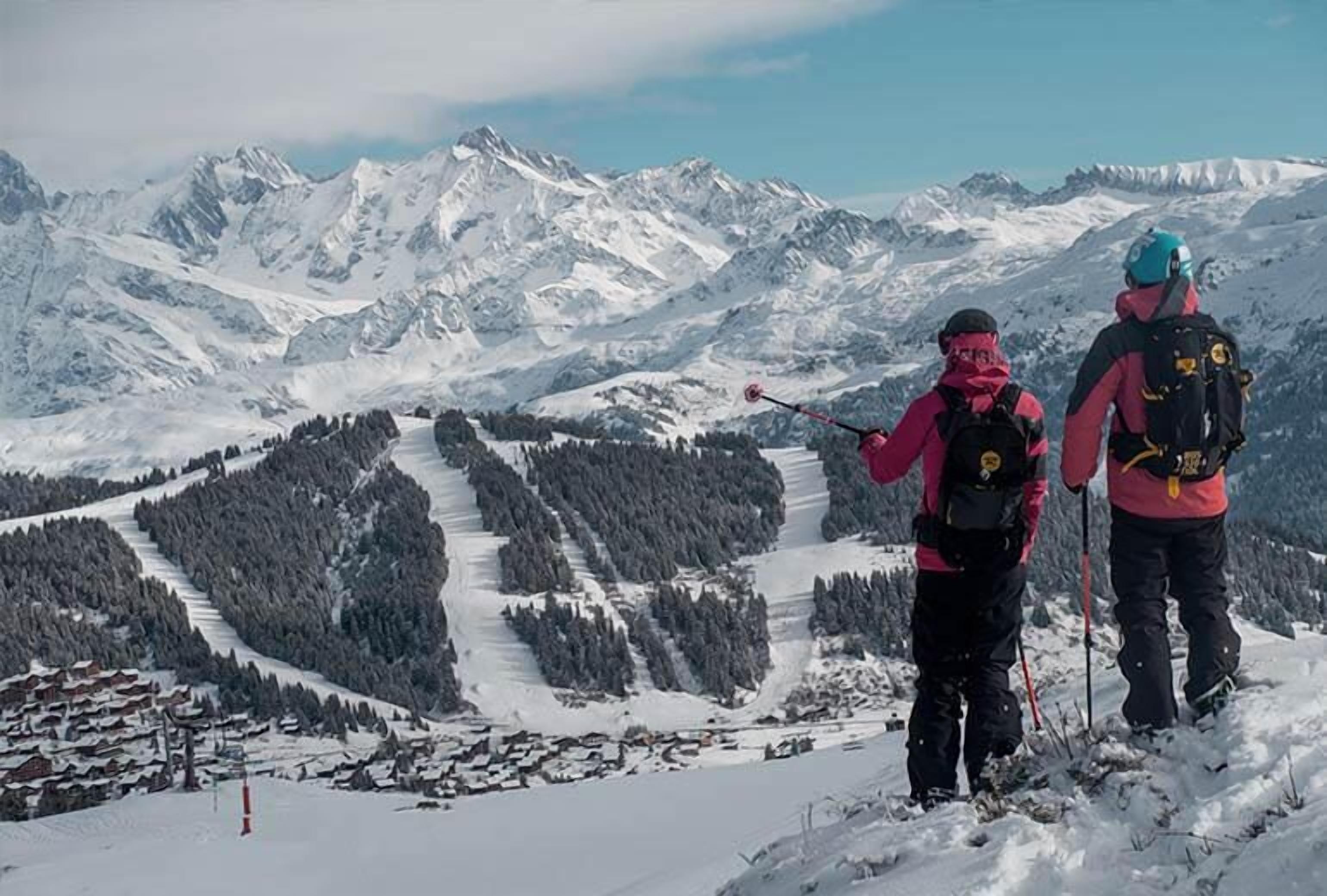 Eine verschneite Berglandschaft mit zwei Wanderern.