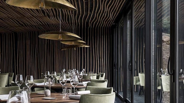 A restaurant interior with wooden slatted ceilings, green upholstered chairs, and tables set for dining. - Maison Aribert (Saint-Martin-d'Uriage)