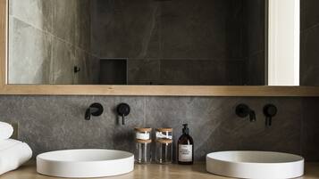 Un baño moderno con dos lavamanos, un espejo grande y una encimera de madera.