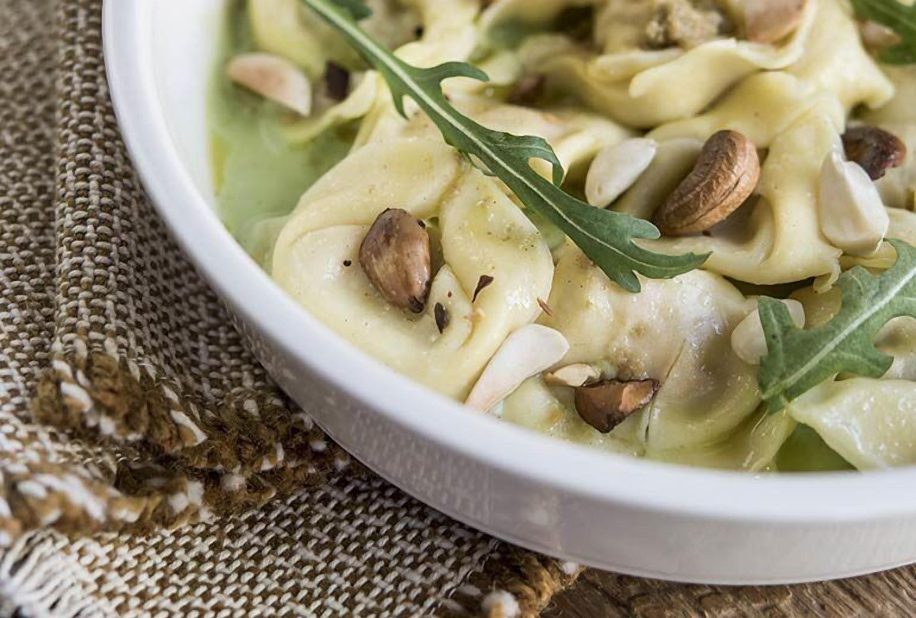 Un bol de raviolis aux noix et aux légumes verts.