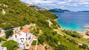 A coastal property with a white building, a swimming pool, and a view of the sea and mountains. - Quiet SeaView Villa Dubrovnik Region (Dubrovacko Primorje)