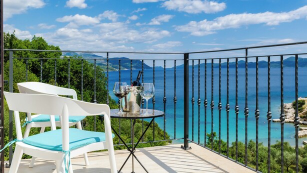 A balcony with a table set for two, overlooking a scenic coastal view. - Quiet SeaView Villa Dubrovnik Region (Dubrovacko Primorje)