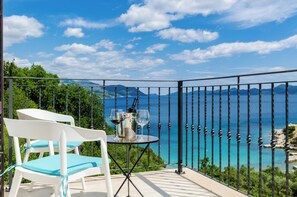 A balcony with a table set for two, overlooking a scenic coastal view. - Quiet SeaView Villa Dubrovnik Region (Dubrovacko Primorje)