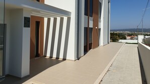 A modern building with a flat roof, large windows, and a clear view of the surrounding area. - Nabaía, ground floor new apartment 7-9 pers. with sea view in Salir do Porto (Salir do Porto)